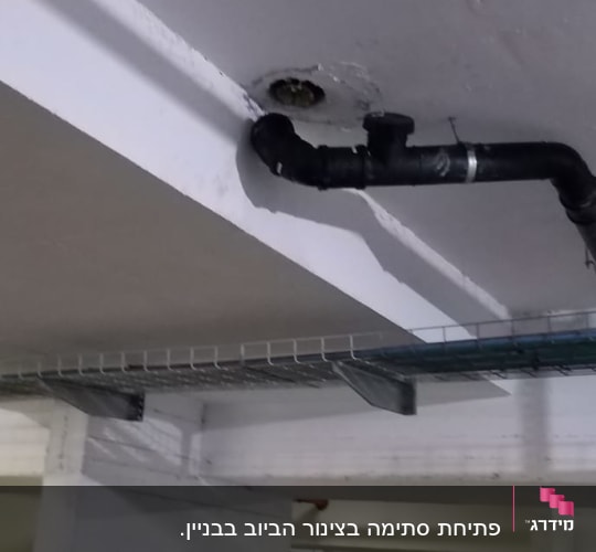 צינור שחור מחובר לתקרה בחניון תת קרקעי